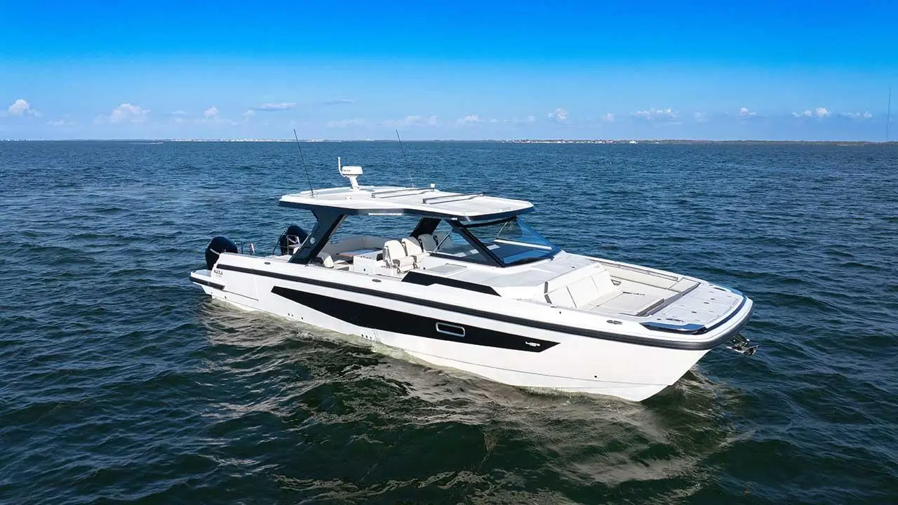 Aquila 45 Sport powerboat cruising on open sea, showing its white hull, hardtop, cockpit and bow sunpad.